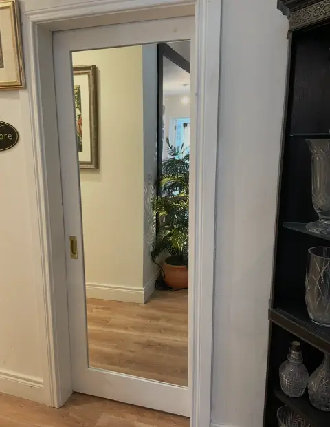 Custom full length mirror mounted on a door for added depth and brightness