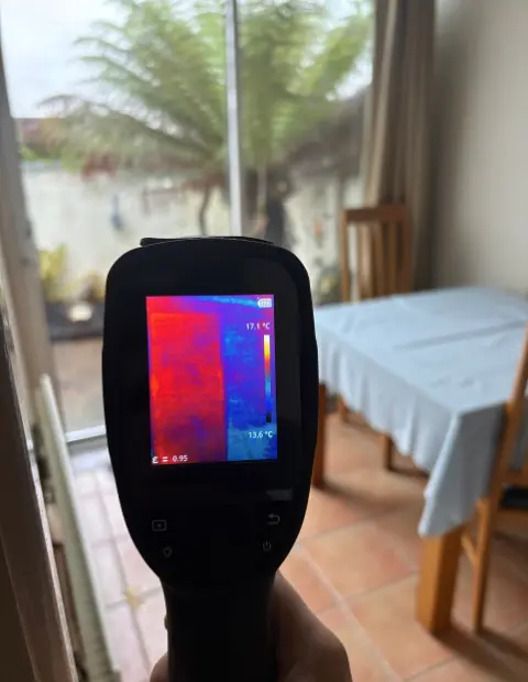 Thermal performance test highlighting Low-E coated glass reflecting heat indoors during a glass-only window retrofit.